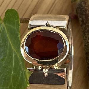 Ring met hessoniet granaat in gouden zetkast.