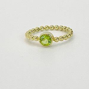 Gouden ring van pareldraad met peridoot, facet geslepen.